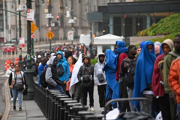 Migrants and asylum seekers line up to enter New York City's immigration center in Federal Plaza in Lower Manhattan